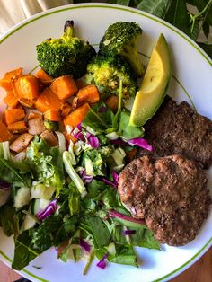 a white plate topped with meat and vegetables