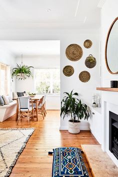 a living room filled with furniture and a fire place next to a dining room table