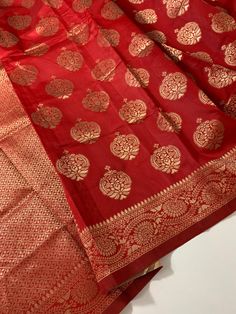 Red Banarasi semi silk saree with antique gold woven zari buttas and border. Saree length is 5.5m.  Saree edging is done. Can be purchased with the paired red aariwork embroidered silk blouse in Sz-34, 36 as in picture  OR just the as Saree Only by choosing in Options. With this saree ensemble you are ready to flaunt your saree immediately in your next party, temple visit, wedding function or at any special occasion  * Disclaimer: The colours might have slight variations due to digital photograp Gold Pre-draped Saree With Traditional Patterns For Festivals, Festive Gold Tussar Silk Anarkali Set, Gold Art Silk Anarkali Set With Zari Weaving, Gold Tussar Silk Anarkali Set With Zari Weaving, Gold Unstitched Katan Silk Anarkali Set, Celebration Chanderi Saree With Zari Weaving, Festive Gold Banarasi Silk Anarkali Set, Festive Gold Banarasi Silk Saree, Gold Banarasi Silk Anarkali Set For Festive Occasions