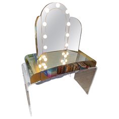 a vanity table with a mirror and lights on it's sides, in front of a white background