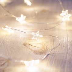 a string of lights that are on a wooden table with the light reflecting off of them