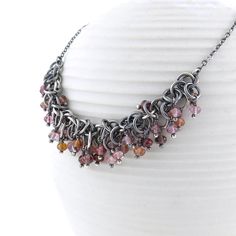 A stunning sterling silver statement necklace, perfect for those who love a subtle mix of color in warm hues of pink, red and orange gemstones.  This particular piece is a base of Shaggy Loops chainmail in which each jumpring is woven into the pattern you see, ring by ring. Wire wrapped within the Sterling Silver chainmail base are faceted gemstone rondelles of 3.5mm to 4mm Multi-Spinel in warm colors, each of the rondelles sitting on Sterling Silver balled headpins. The chainmail is then connec Pink Sterling Silver Necklaces With Stones, Pink Sterling Silver Necklace With Stones, Orange Gemstones, Spinel Necklace, Pink Statement Necklace, Ring Wire, Silver Necklace Statement, Silver Flats, Cluster Necklace