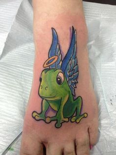 a green frog with blue wings on its foot is shown in this tattoo design by person