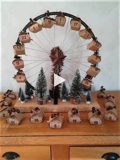 a wooden table topped with lots of christmas decorations and a ferris wheel in the background