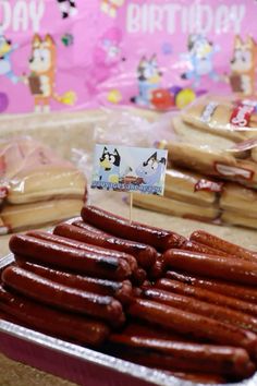 there are many hotdogs on the table and one has a happy birthday sign