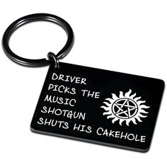 a black keychain with the words driver picks the music shotgun shuts his cakehole