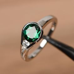 It is an emerald ring(lab emerald). The emerald is 7mm*7mm round, weight about 1.29 carats. The basic metal is sterling silver and plated with rhodium. To change the metal to a solid gold (white/rose) or platinum is also available, please ask for a quotation if you want. You can also go to my shop Home for more elegant rings:  https://www.etsy.com/shop/godjewelry?ref=hdr_shop_menu Emerald is May birthstone. More emerald rings: https://www.etsy.com/shop/godjewelry?ref=hdr_shop_menu&section_id=207 May Birthstone Rings, Round Cut Engagement Rings, Engagement Rings Round, Emerald Engagement, Emerald Engagement Ring, Emerald Jewelry, Elegant Ring, Diamond Solitaire Engagement Ring, Ring Gemstone