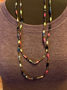 Colorful lightweight single strand necklace shown here doubled over.  Larger beads appear to be made from varnished paper. Multicolor Wooden Beads Long Necklace Gift, Handmade Multicolor Double Strand Long Necklace, Multicolor Double Strand Necklace With Large Beads, Multicolor Double Strand Beaded Necklace With Large Beads, Adjustable Multicolor Long Necklace With Faceted Beads, Multicolor Necklace With Oval Wooden Beads, Handmade Multicolor Double Strand Necklace, Multicolor Oval Wooden Beads Necklace, Multicolor Wooden Beads Oval Necklaces