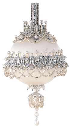 an ornament hanging from the ceiling with pearls and crystals on it's sides