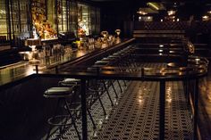 a dimly lit bar with stools and tables