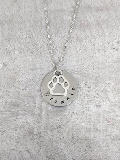 This stainless steel diamond cut necklace is adorned with an 18mm aluminum plate with your pet's name layered with a paw print charm. Necklaces are available in 18 or 20 inch lengths. You may add additional names during checkout. Additional names are included as an additional disc and paw print charm. Please leave the name (s) in the personalization box. All items arrive boxed and ready for gift giving. Similar items can be found in the pet section of my shop, including different dog breed optio Paw Print Necklace, Paw Print Charm, Pet Name, Dog Mom Gifts, Pet Names, Cat Mom, Cat Gifts, Mom Gift, Dog Mom