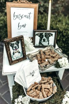 there is a dog treat in the bowl and some pictures on the table behind it