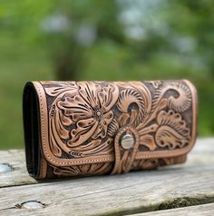 "Hand-tooled leather wallet, in a deep floral design, opens wide to a variety of organizational features. Pretty while still being a great size to fit in your bag or carry alone as a clutch! Beautiful floral design on both sides of the wallet.  Made from 100% genuine leather, each bag varies in shading due to the thickness which is determined by the age of the animal and the natural creases of the leather itself: hence, each bag's color and characteristics are truly one-of-a-kinds. Dimensions: 7 Rodeo Style, Tooled Leather Wallet, Statement Clutch, Rodeo Fashion, Brown Leather Wallet, Clip Wallet, Coin Wallet, Hand Tooled Leather, Wallet Gifts