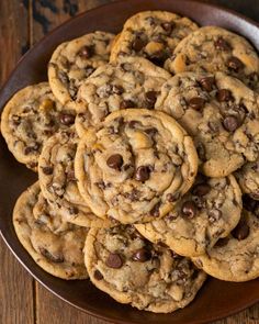 a plate full of chocolate chip cookies on a wooden table