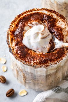 a chocolate dessert with whipped cream on top and almonds around the rim, sitting on a table