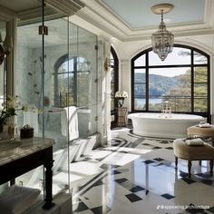 a large bathroom with an oval tub and checkered flooring on the walls, windows, and chandelier