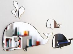 a mirror that has some kind of whale on it's face and is hanging on the wall