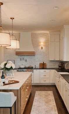 a large kitchen with white cabinets and wooden flooring, along with an area rug in the middle