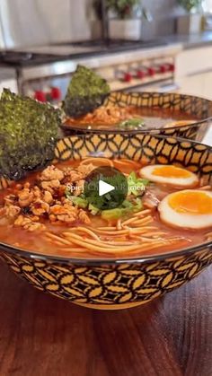 two bowls filled with noodles, broccoli and an egg on top of them