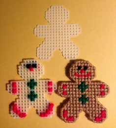 two cross stitch teddy bears sitting next to each other