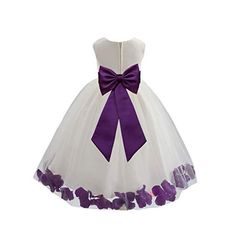 a white dress with purple flowers on the skirt and a bow at the waistline