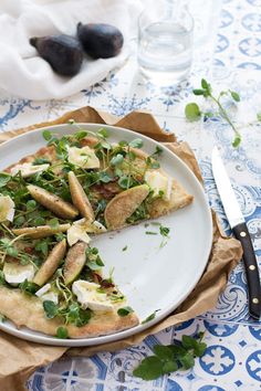 a white plate topped with slices of pizza on top of a blue and white table cloth