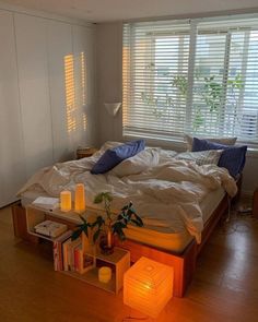 a bed sitting in a bedroom next to a window with blinds on the windowsill