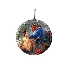 a stained glass ornament depicting the beauty and the beast