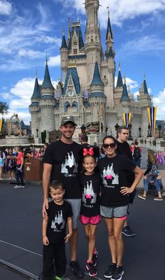 a man and two children standing in front of a castle at disney world with their dad