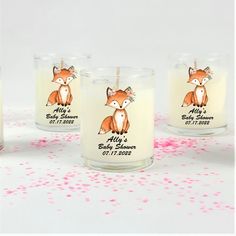 three candles with stickers on them sitting next to confetti