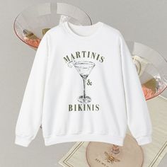 a white sweatshirt with martinis and bikinis printed on it