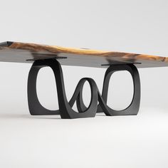 a wooden bench with black metal legs and a piece of wood on the back side