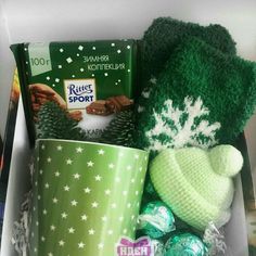 a box filled with assorted items including a knitted hat, coffee cup and candy