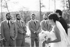 a bride and groom standing in front of their wedding party at the end of an outdoor ceremony