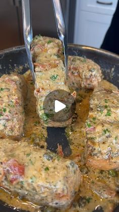 the food is being cooked in the skillet with tongs to stir them together