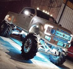 a large truck with big tires parked in a garage