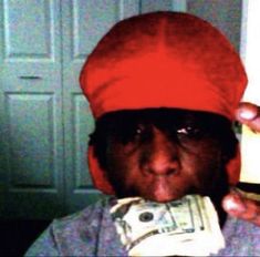 a man wearing a red turban is holding money in front of his face