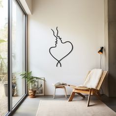 a chair sitting in front of a window next to a wall with a heart drawn on it