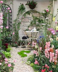 a table and chairs in a garden with flowers