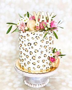 a leopard print cake with flowers and the word yay on top