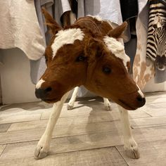 two horses standing next to each other in front of clothes on display at a store