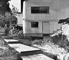 black and white photograph of people sitting on benches in front of a building