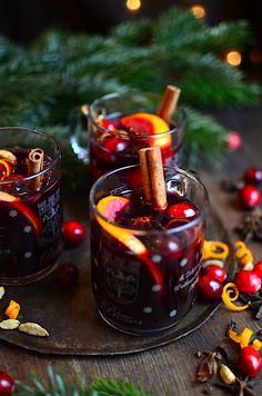 two glasses filled with red liquid and cinnamon sticks