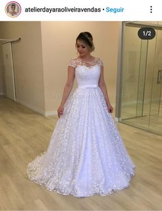 a woman in a white wedding dress standing on a wooden floor