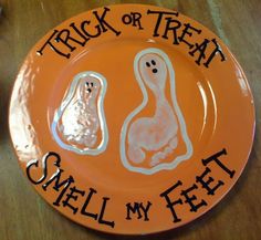 an orange plate with two ghost faces on it and the words trick or treat smell my feet