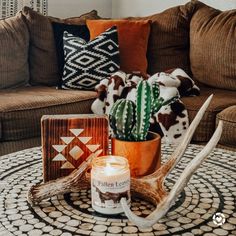 a living room with a couch, coffee table and deer antlers