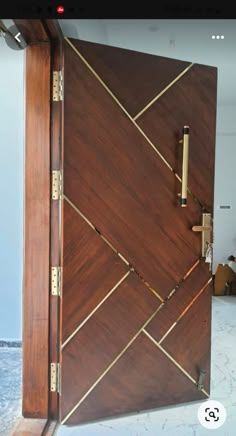 a large wooden door with brass hardware on the front and side panels inlays