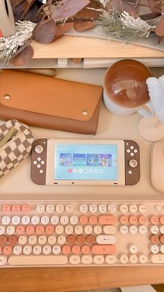 a computer keyboard sitting on top of a wooden desk next to a mouse and cell phone