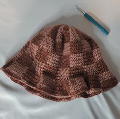 a crocheted hat and toothbrush on a bed