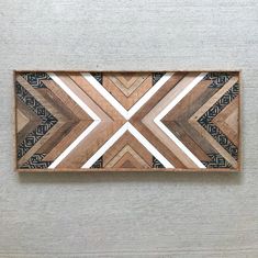 an art piece made out of wood with geometric designs on the bottom and one side